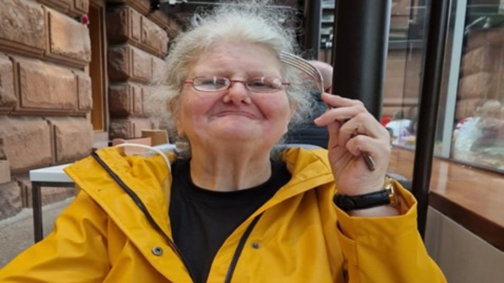Image shows catherine smiling to camera enjoying lunch